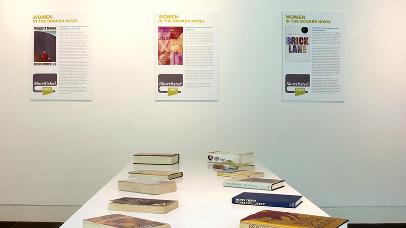 Display of books on a table with information boards behind.